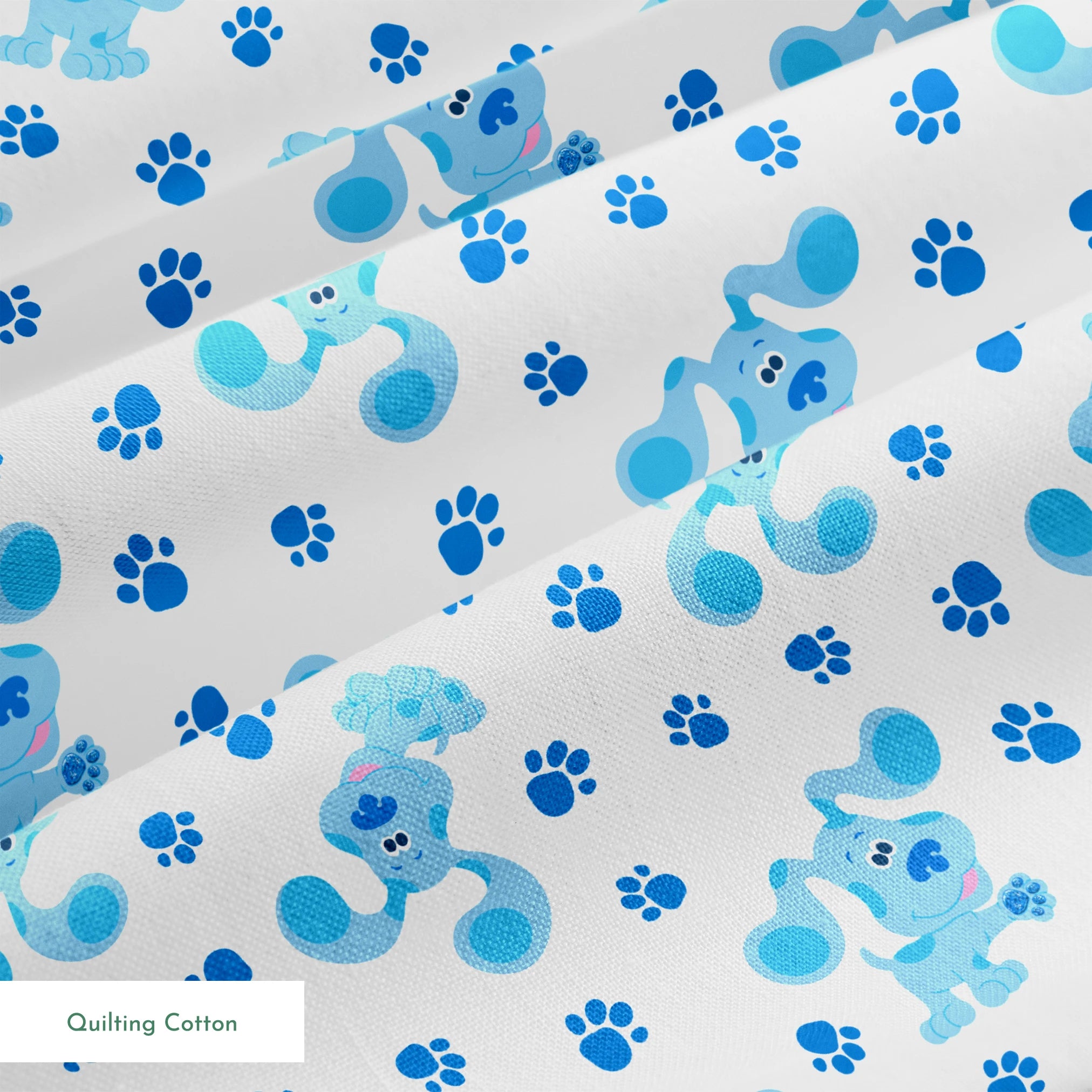 Blue cartoon puppies with floppy ears scattered among paw print pattern on white background springs quiltingcotton texture