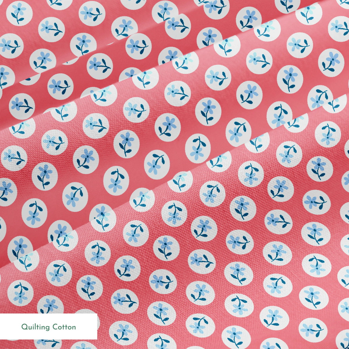 Coral pink background with white circles containing light blue floral designs arranged in a pattern springs quiltingcotton texture