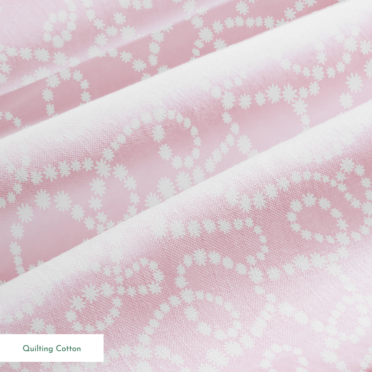 Baby pink background with white dotted swirling pattern creating delicate curved lines and loops springs quiltingcotton texture