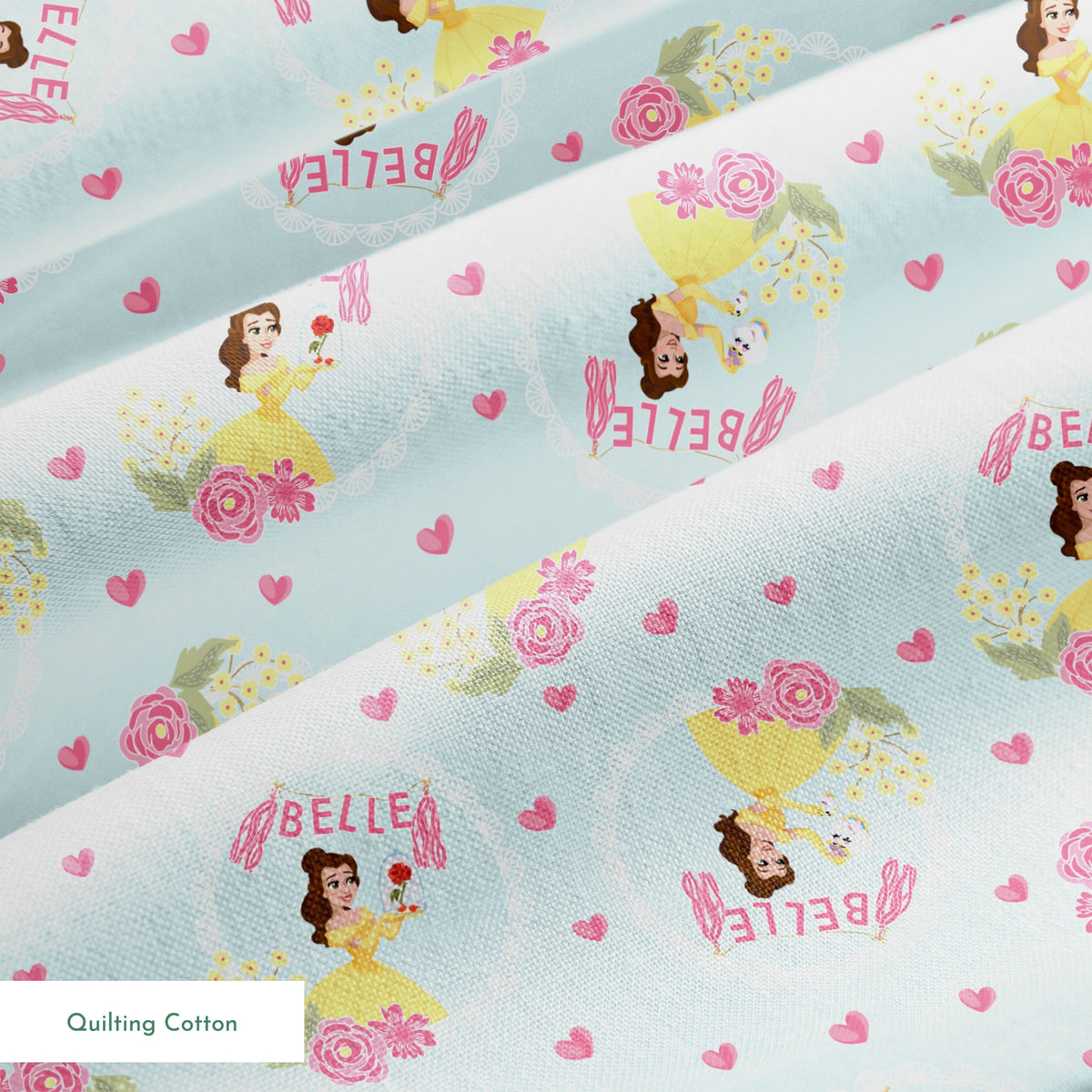 Princess Belle pattern with yellow dress, "Belle" text, hearts, and flowers on light blue background springs quiltingcotton texture