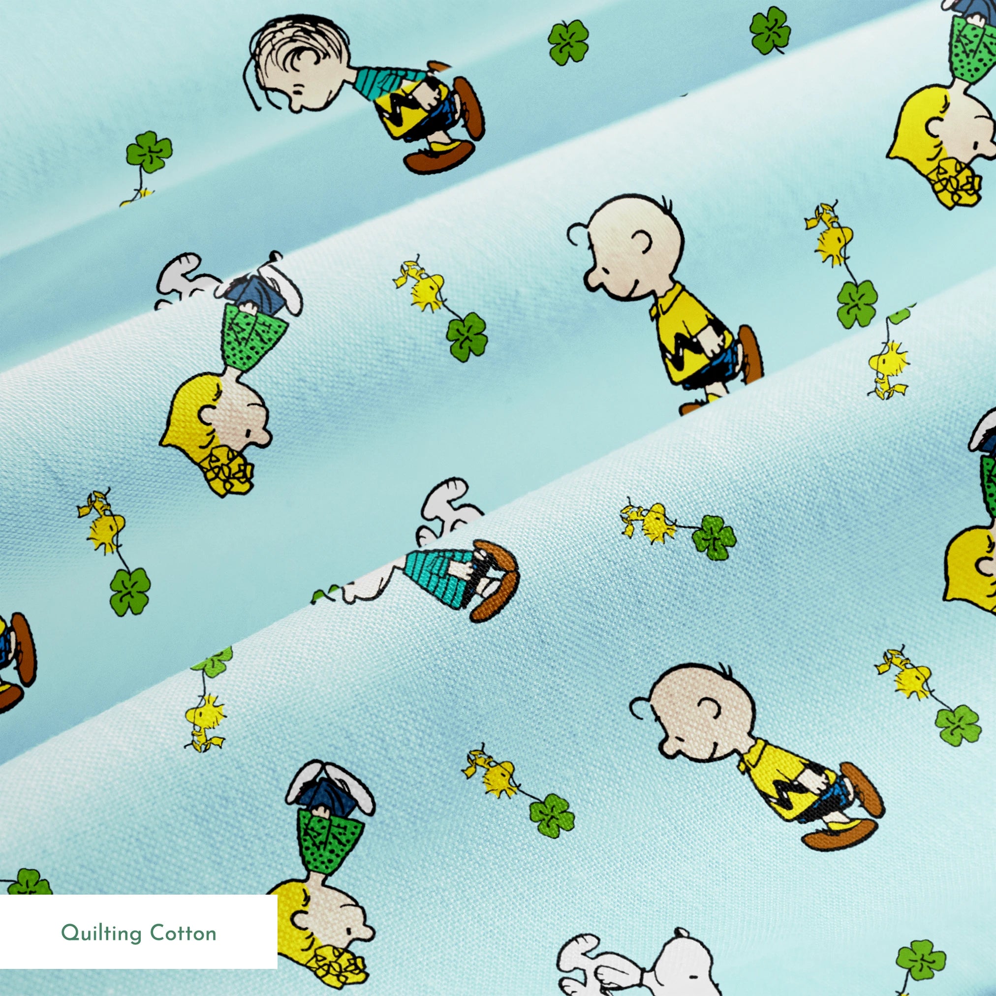 Peanuts cartoon characters on light blue background with clovers springs quiltingcotton texture