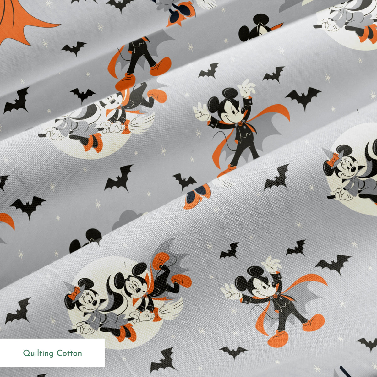 Mickey and Minnie Mouse in Halloween costumes on gray background with bats and moons, orange capes and spooky theme. springs quiltingcotton texture