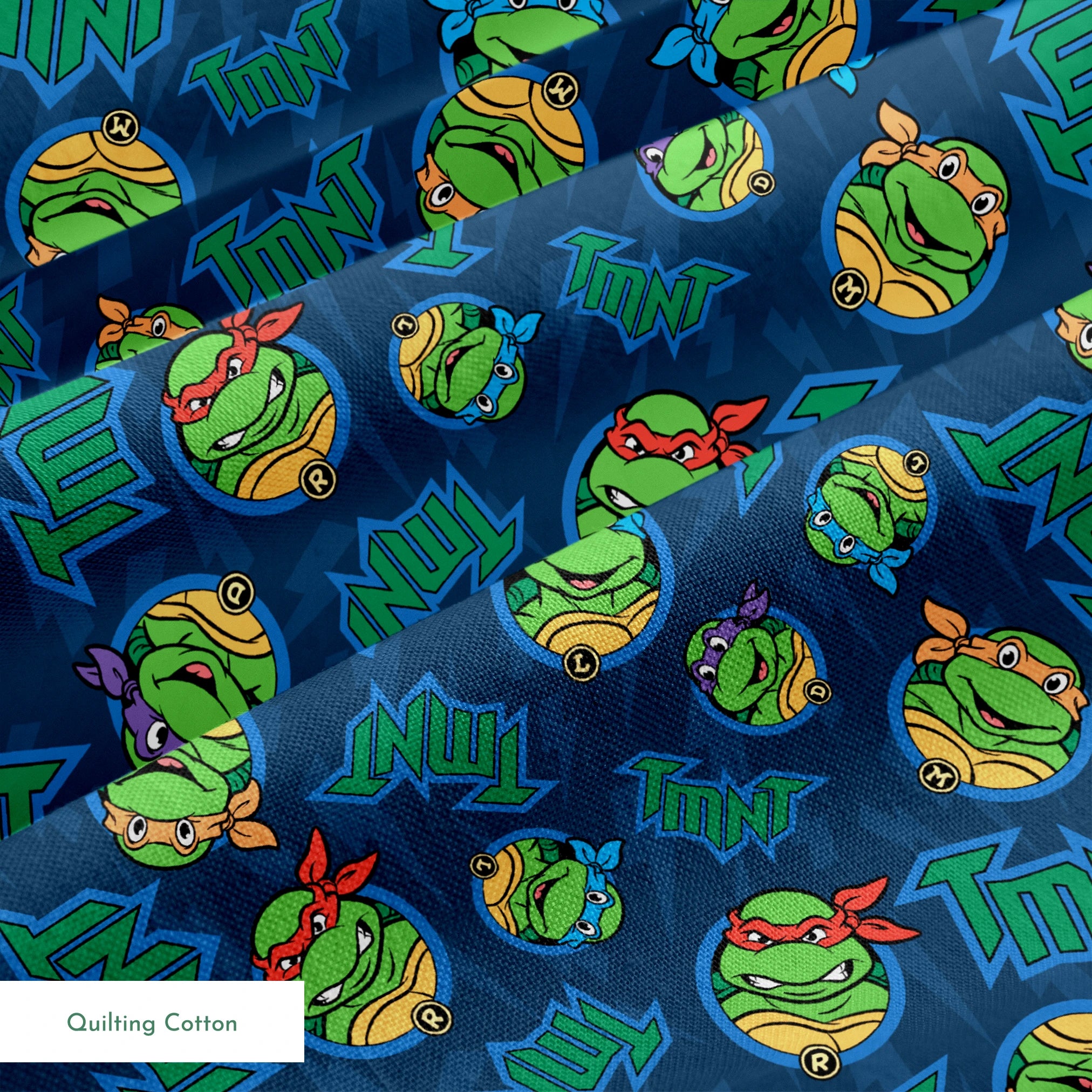 Teenage Mutant Ninja Turtles pattern with character heads and TMNT logos on blue background springs quiltingcotton texture