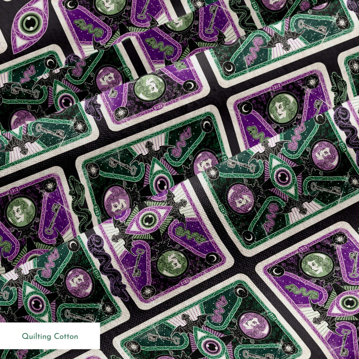 Ornate playing card designs with purple and green patterns featuring central eye motifs and circular number elements against a black background. springs quiltingcotton texture