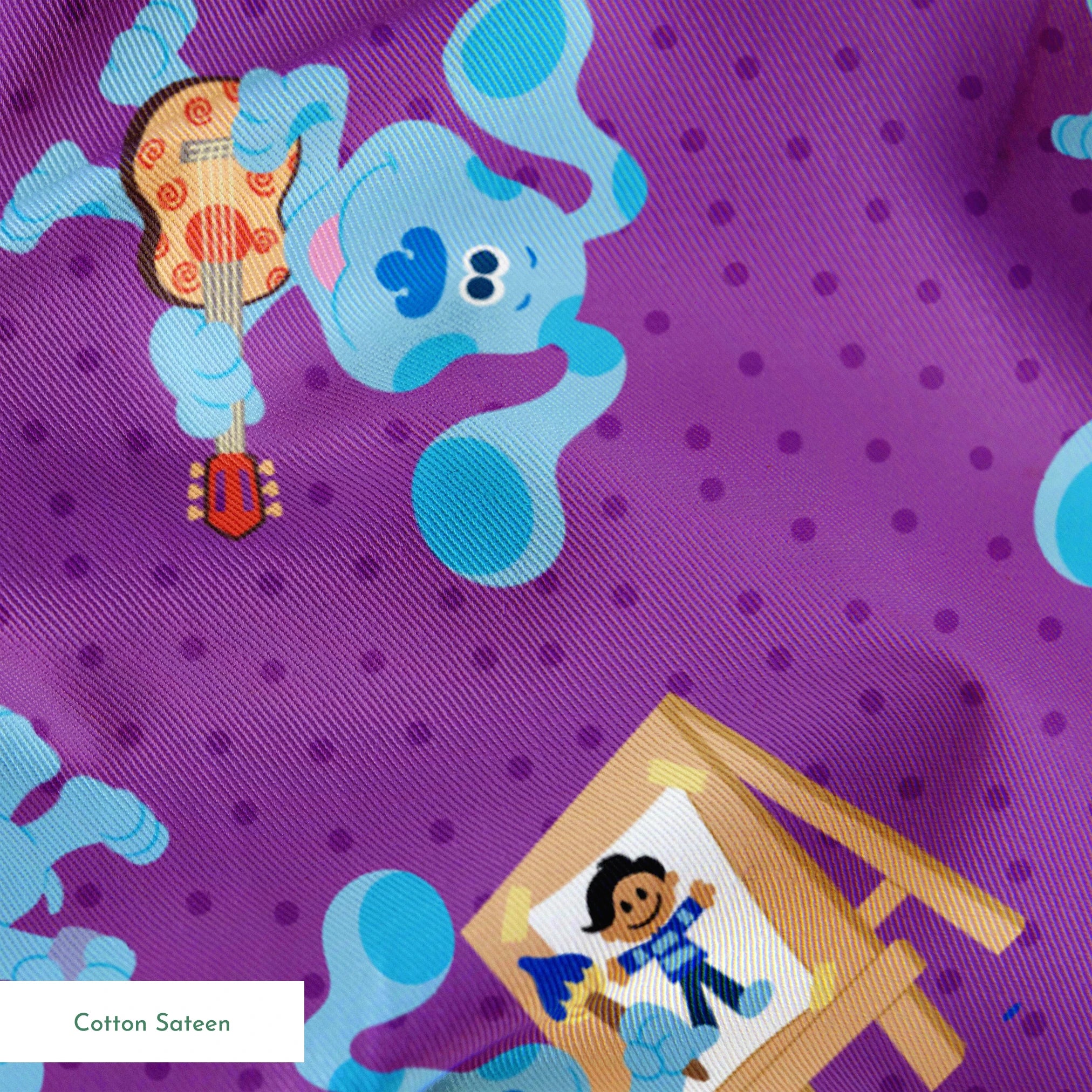 Blue cartoon dog characters on purple polka dot background with toys and alphabet blocks pattern springs sateen texture