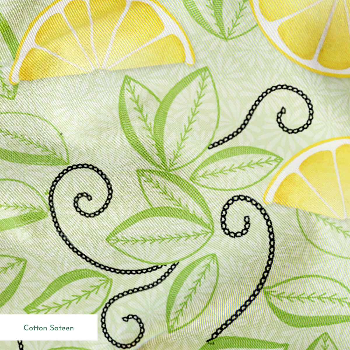 Yellow lemon slices with swirling green leaves on a soft green background in a playful, fresh layout. springs sateen texture