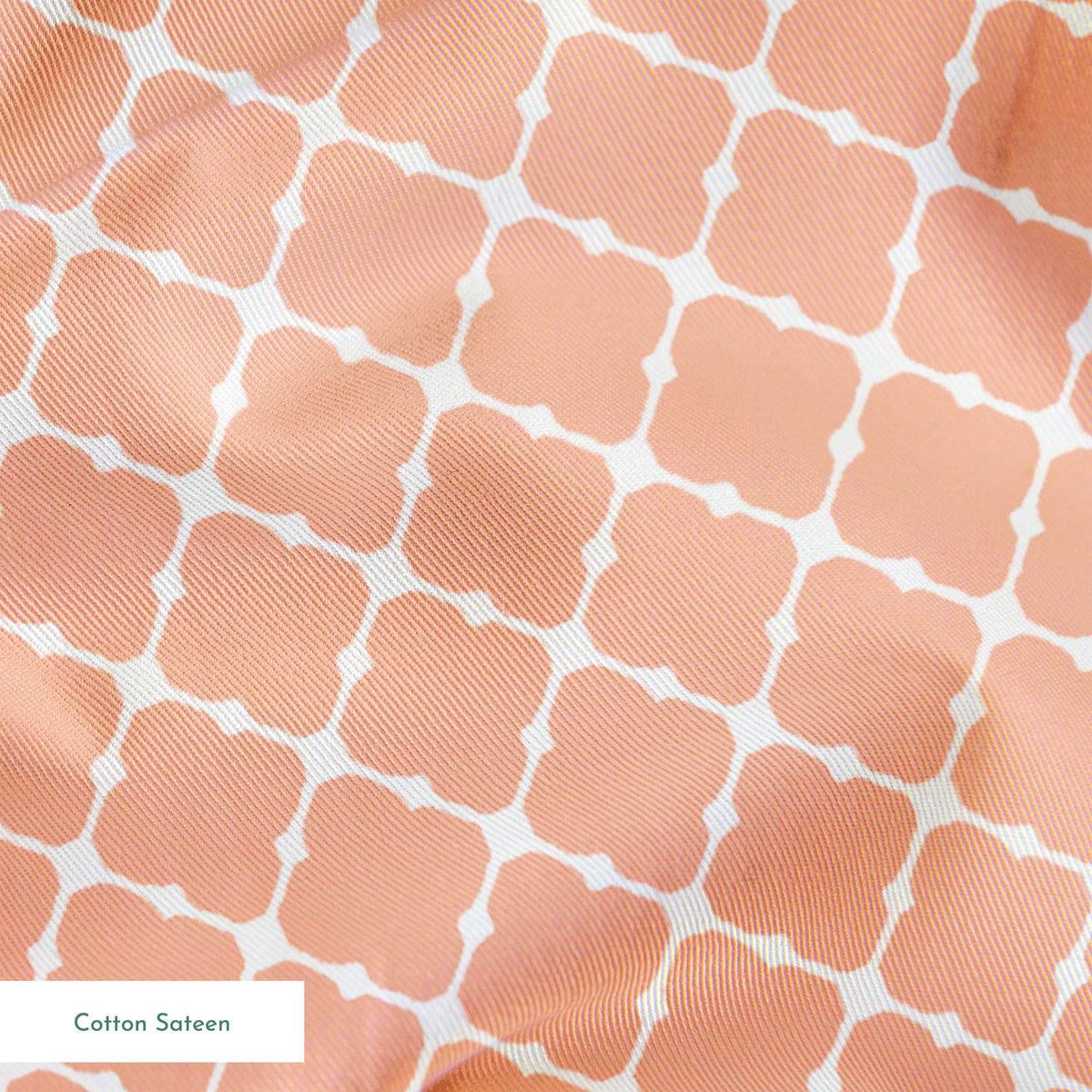 Peach and white quatrefoil pattern with regular geometric shapes in a lattice arrangement springs sateen texture