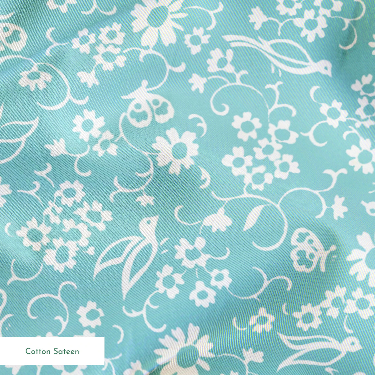 Delicate white floral pattern on a soft turquoise background with swirling leaf motifs springs sateen texture