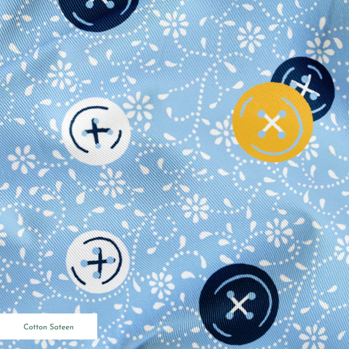 Blue background with scattered circular buttons in white, navy, and gold, each featuring cross designs, on a floral pattern. springs sateen texture