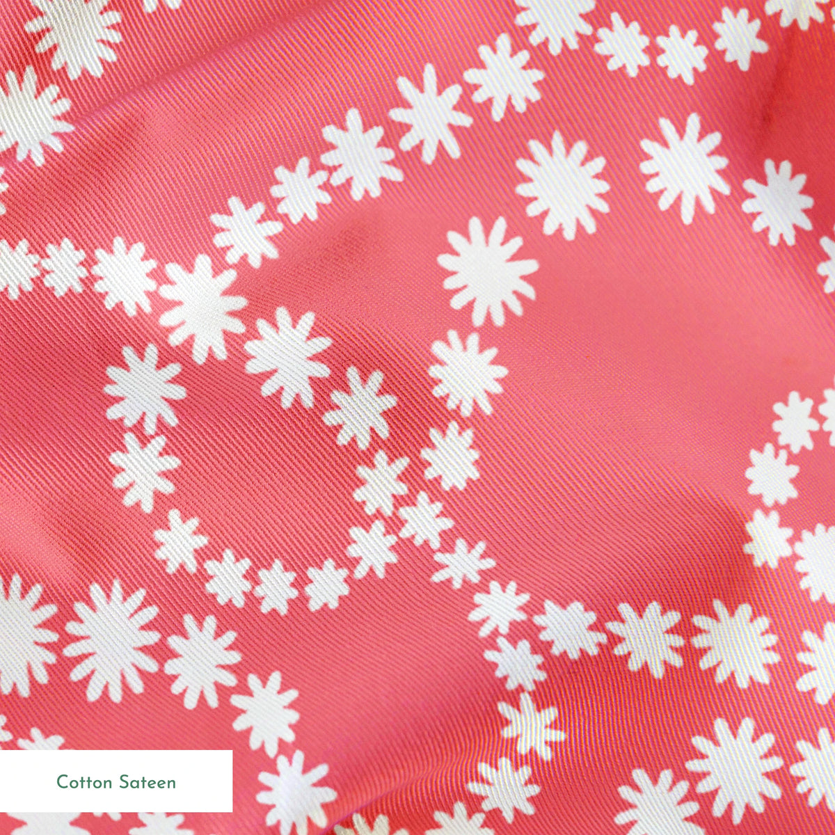 White dot patterns forming swirling chains on coral pink background springs sateen texture