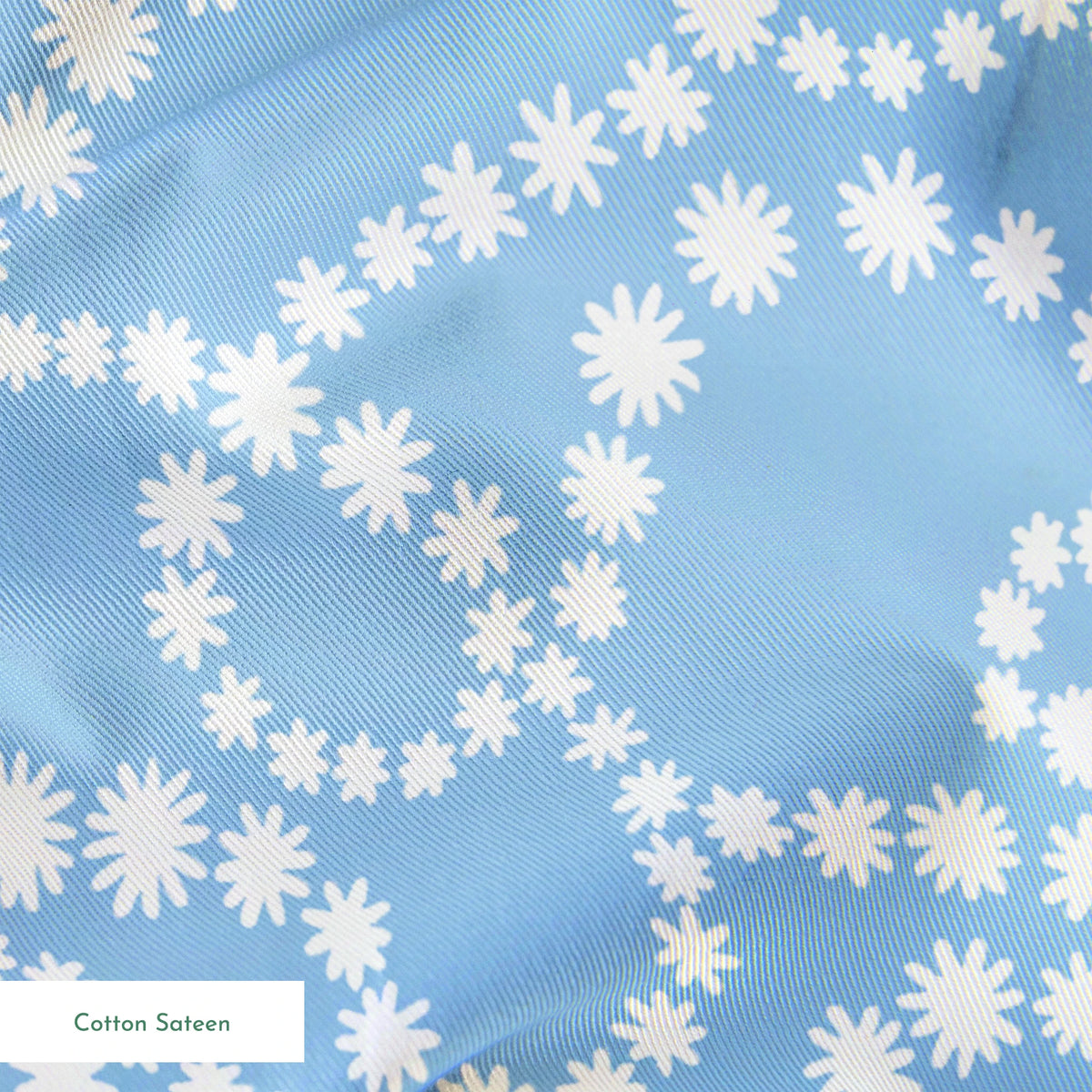 Pale blue background with white dotted swirling pattern resembling strings of pearls or bubbles in abstract curves springs sateen texture
