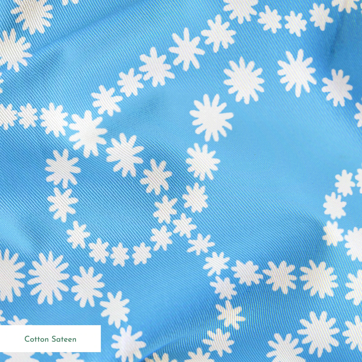 Sky blue background with swirling white dotted pattern resembling beaded strings or pearls arranged in curving lines springs sateen texture