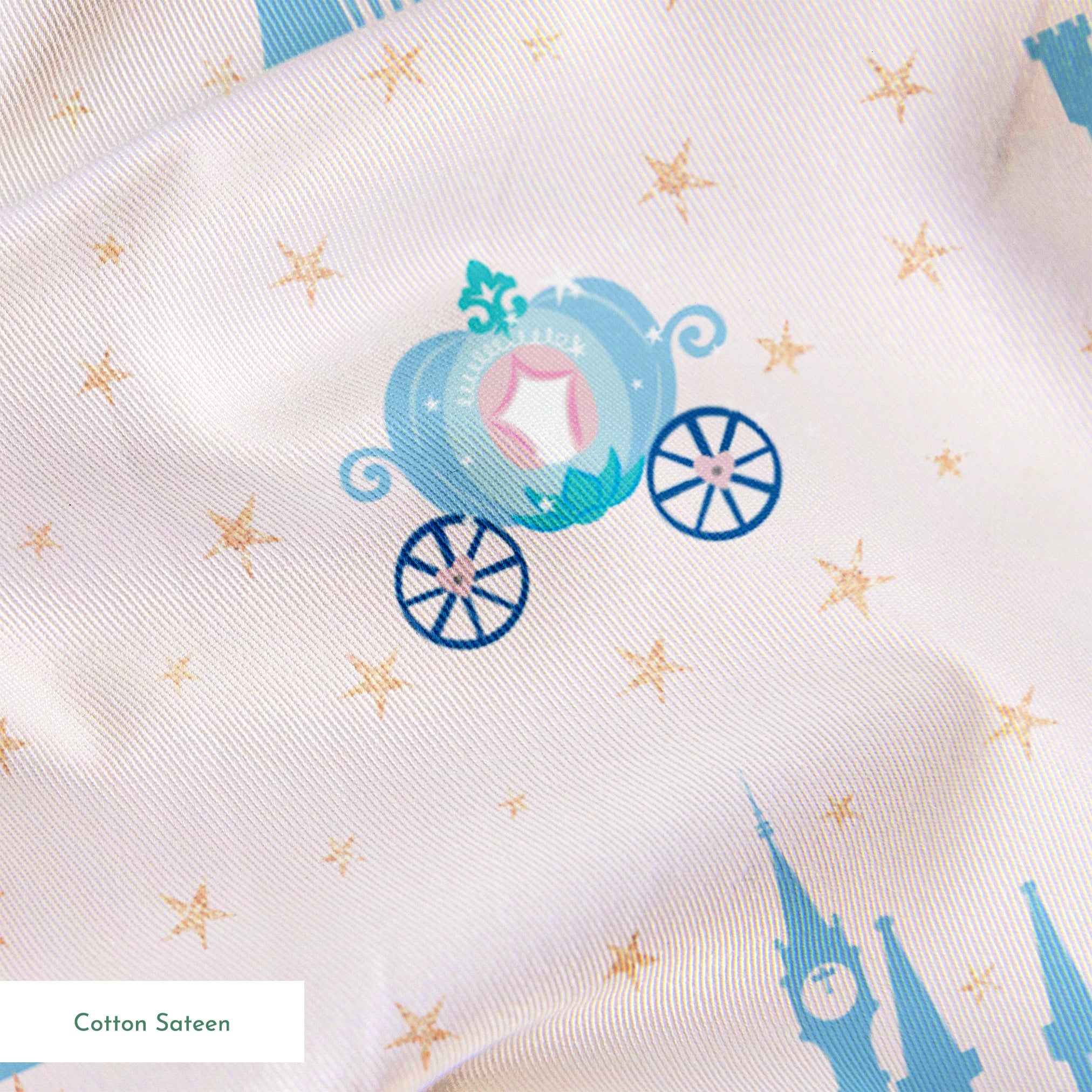 Cinderella pattern with blue castles, carriages, and gold stars on pale pink background springs sateen texture