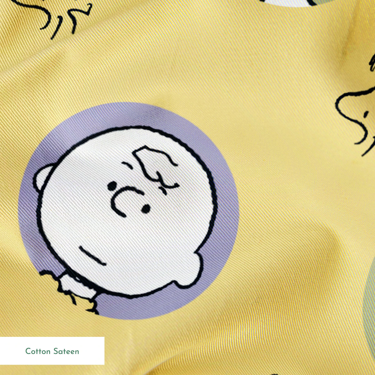 Peanuts characters pattern with Charlie Brown and friends in circular frames on yellow background with Woodstock silhouettes springs sateen texture