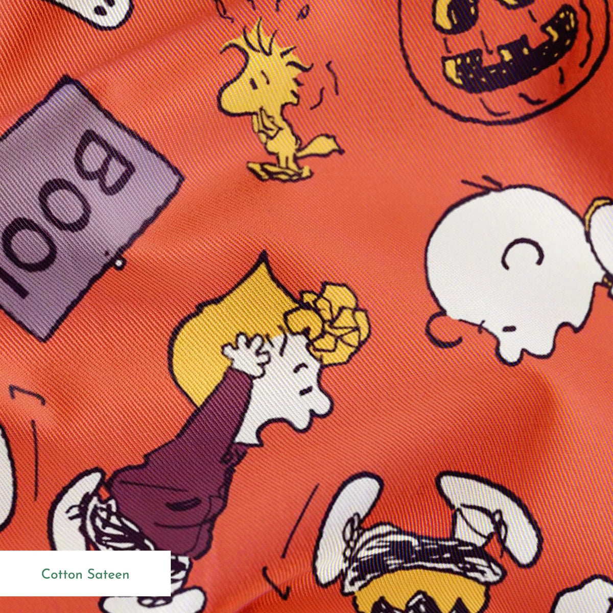 Snoopy and Woodstock Halloween pattern on orange background with pumpkins, ghosts, and "boo" text springs sateen texture
