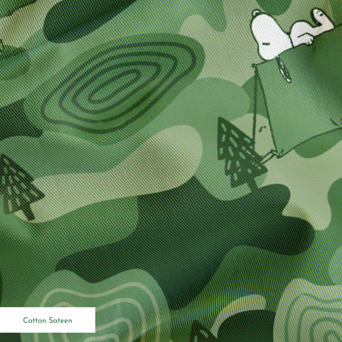 Snoopy camping scene with tents and trees on a green camouflage pattern background springs sateen texture