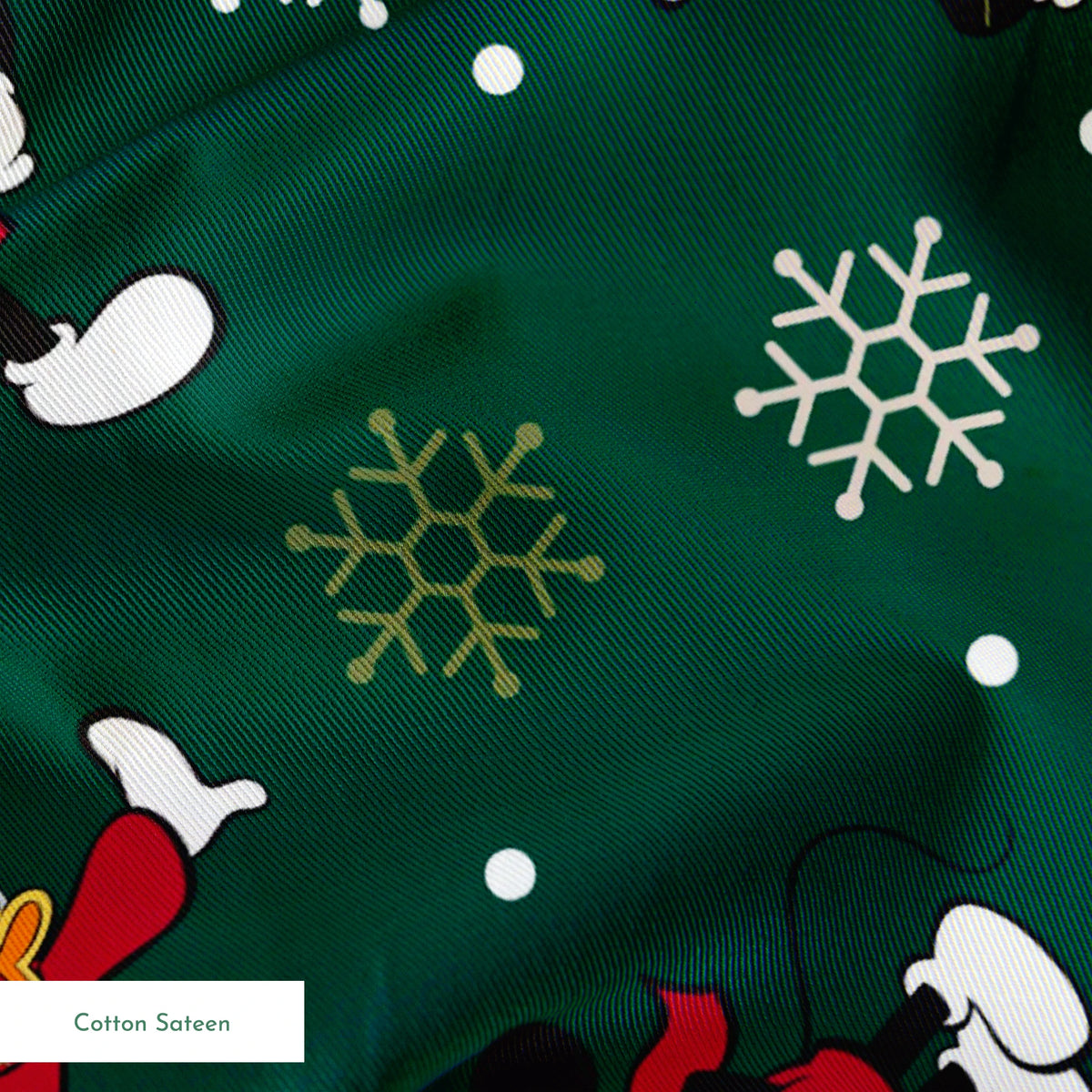 Mickey Mouse Christmas pattern with cartoon characters in winter outfits on green background with snowflakes springs sateen texture