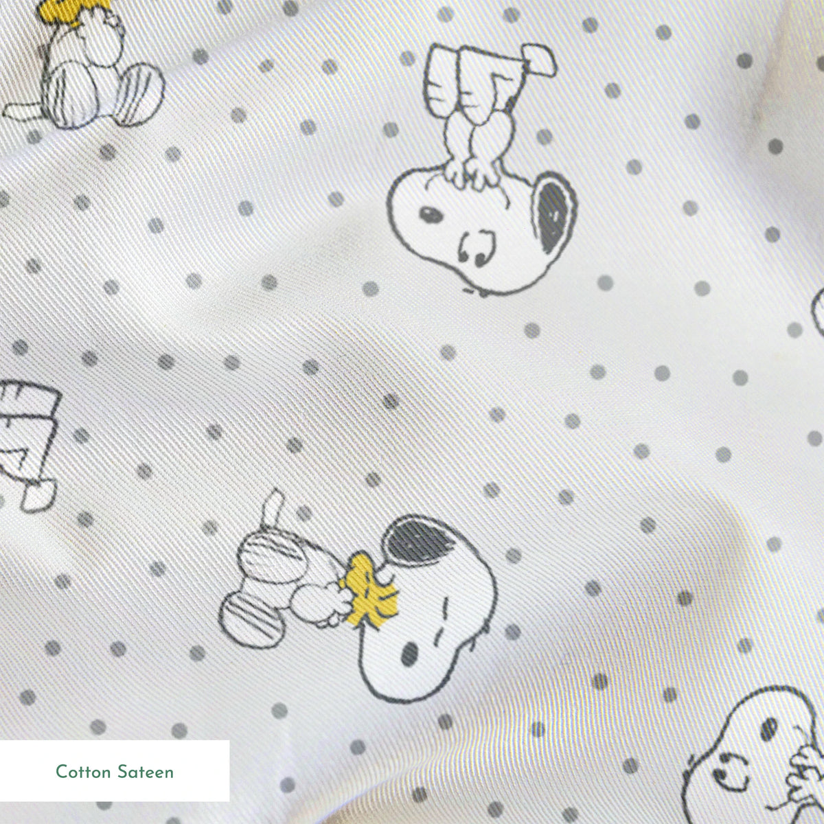 Snoopy and Woodstock on polka dot background in a repeating pattern springs sateen texture