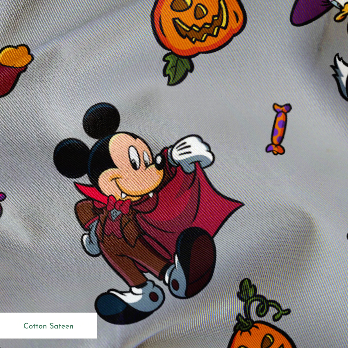 Halloween-themed cartoon pattern with Mickey Mouse characters in costumes, pumpkins, candy, and cauldrons on gray background springs sateen texture
