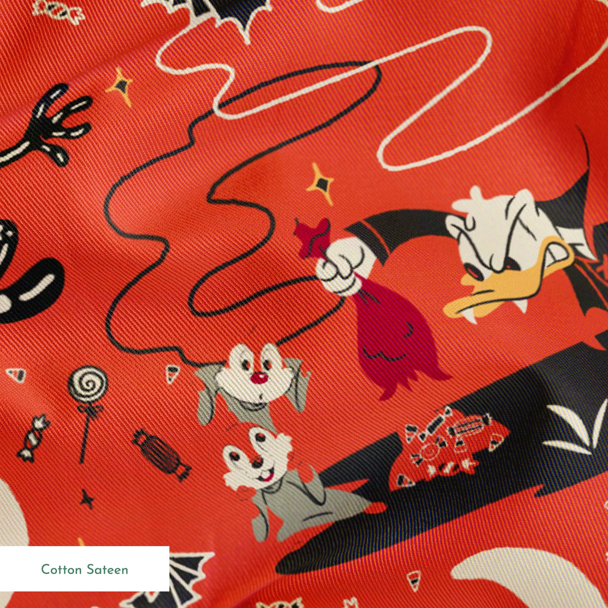 Halloween-themed Disney pattern with Mickey, Minnie, Donald in skeleton costumes on orange background with bats and moons springs sateen texture