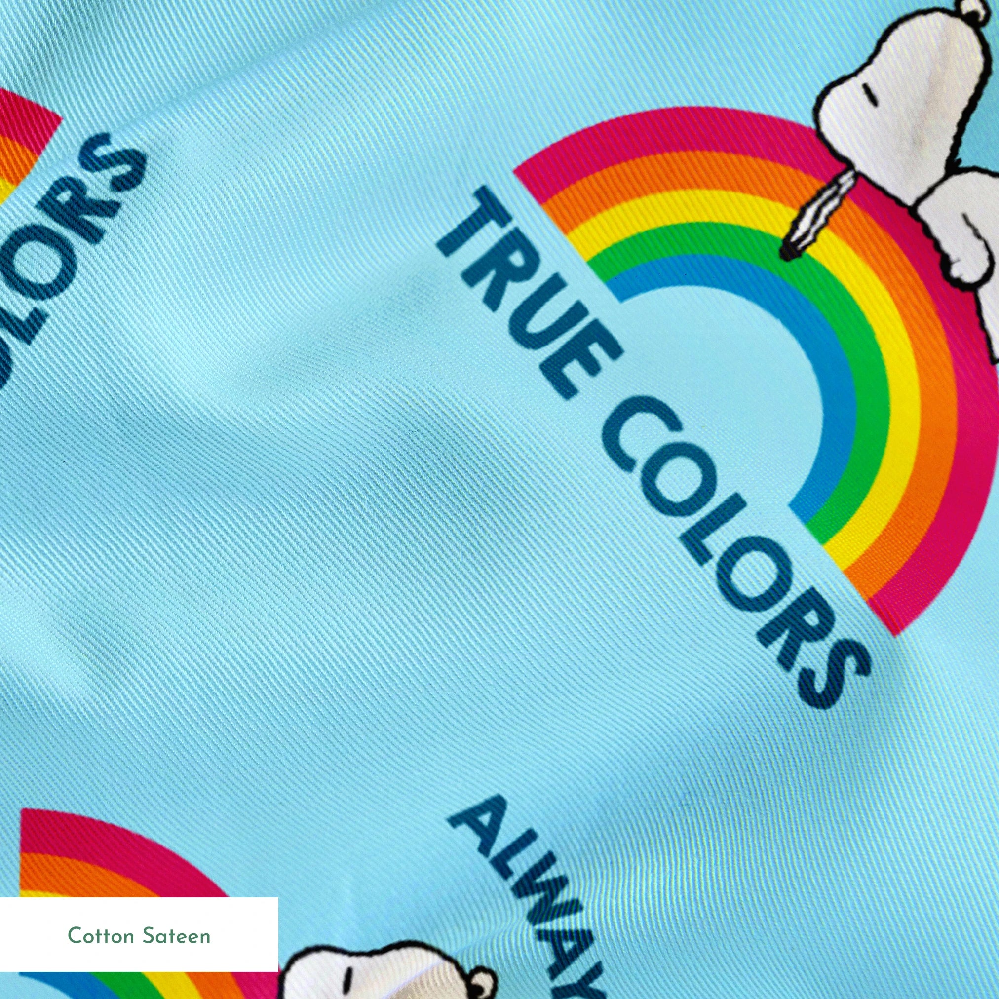 Rainbow Snoopy pattern on light blue background with white clouds and "TRUE COLORS" and "ALWAYS SHOW YOUR" text repeated throughout design springs sateen texture