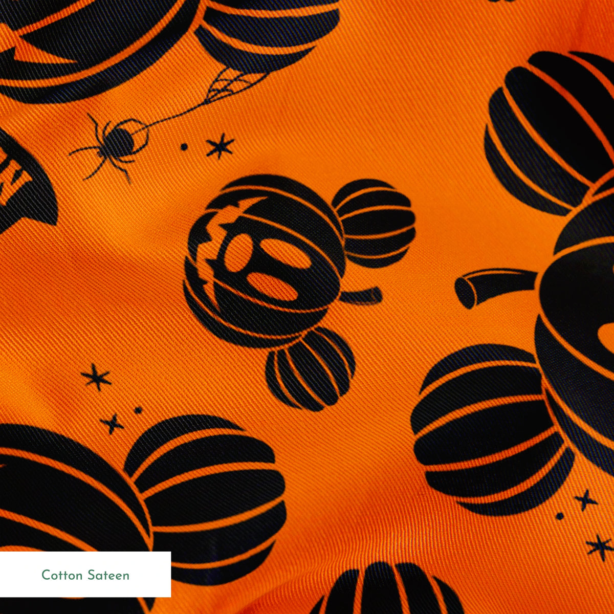 Halloween pattern with Disney-inspired jack-o'-lantern pumpkins and "Happy Halloween" text on bright orange background springs sateen texture