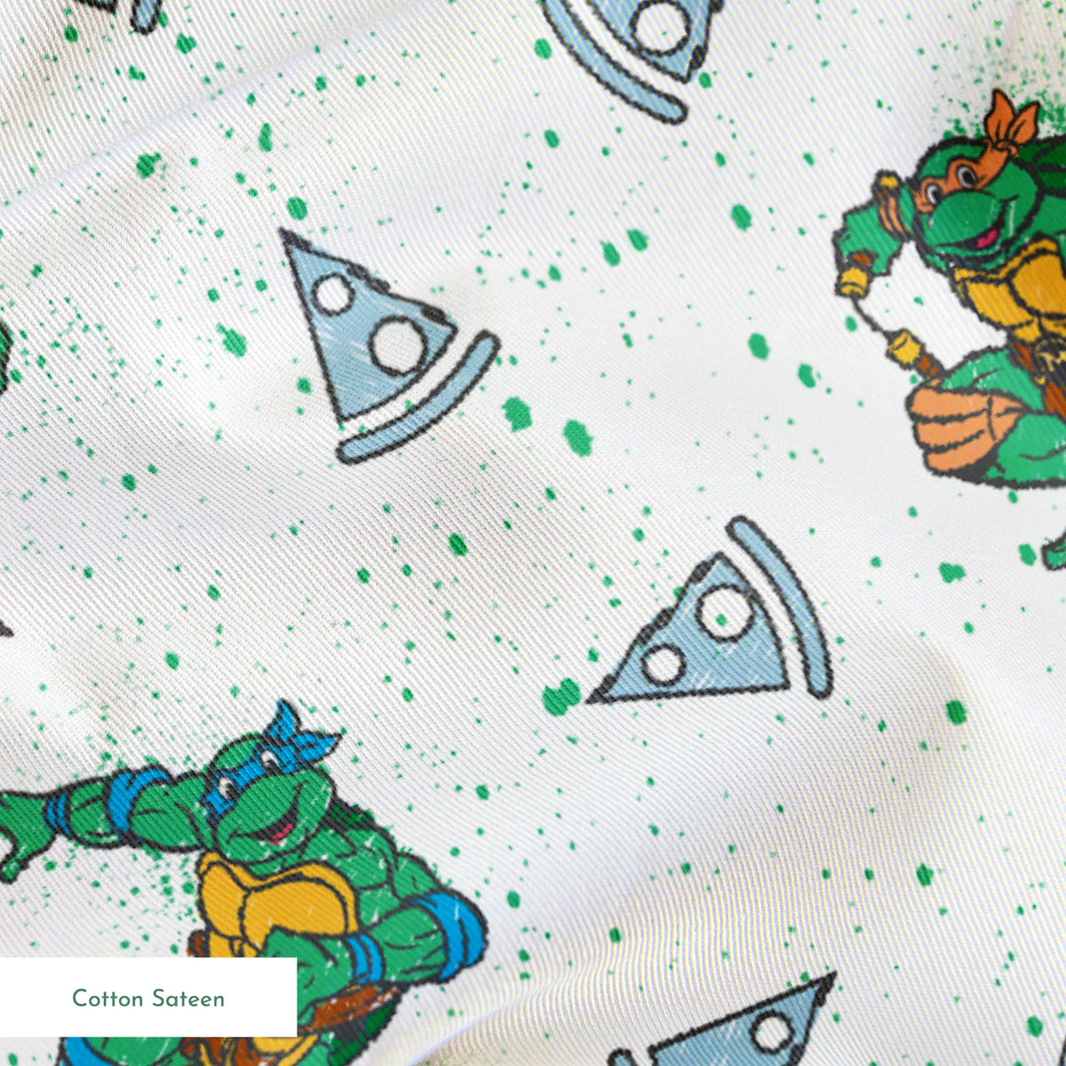 Teenage Mutant Ninja Turtles in action poses scattered among pizza slices on white speckled background springs sateen texture