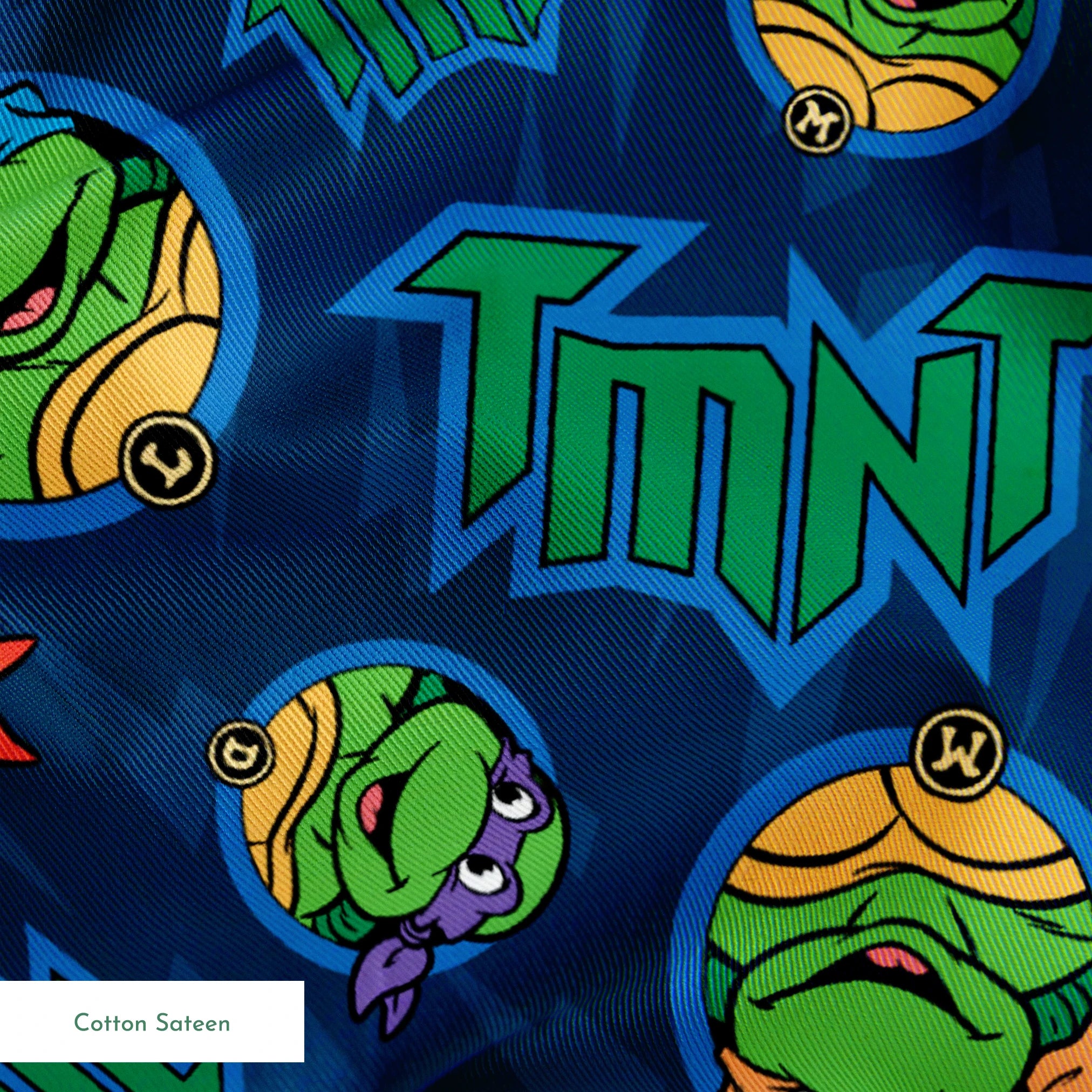 Teenage Mutant Ninja Turtles pattern with character heads and TMNT logos on blue background springs sateen texture