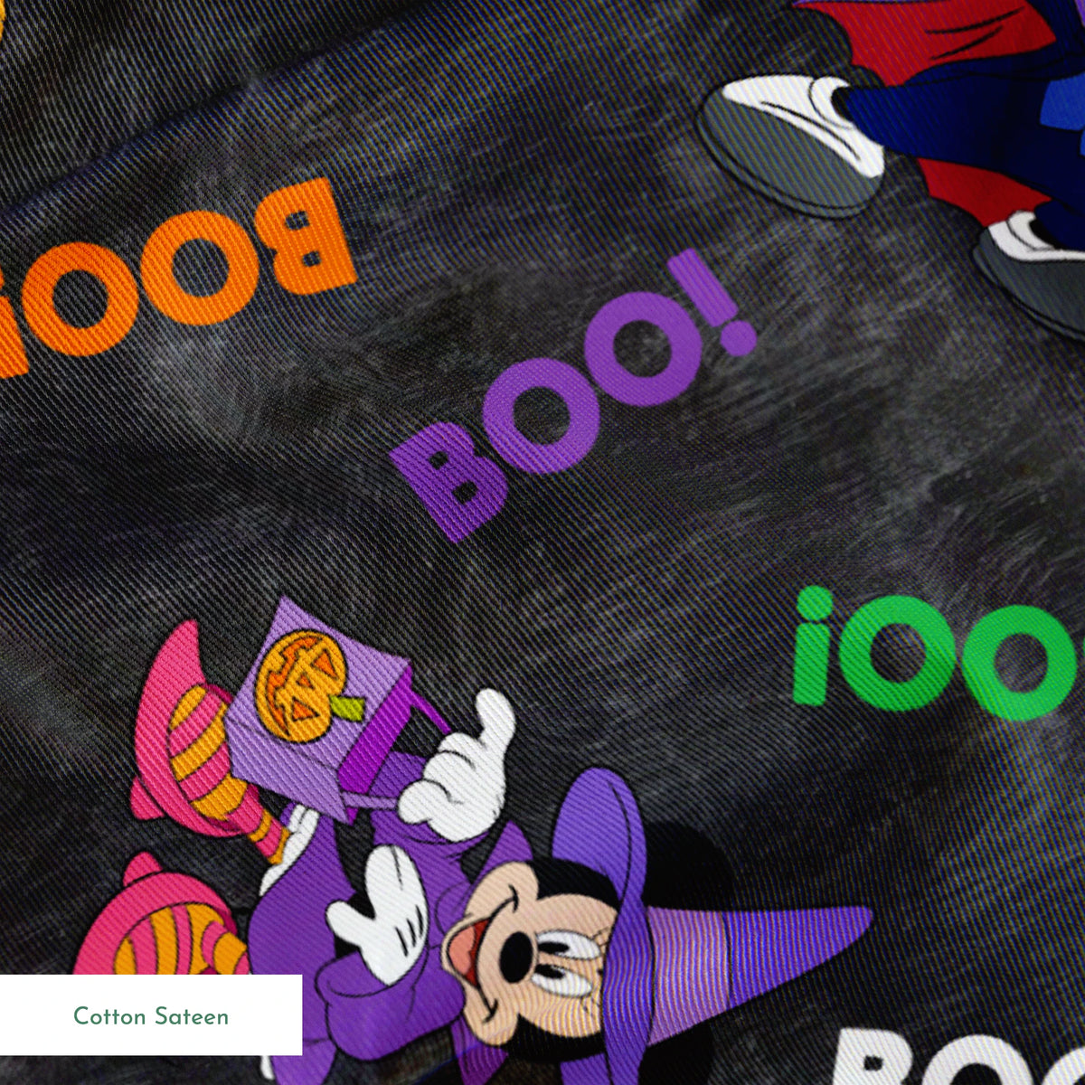 Halloween themed pattern with Disney characters in costumes, pumpkins, and colorful "BOO!" text on dark gray background. springs sateen texture