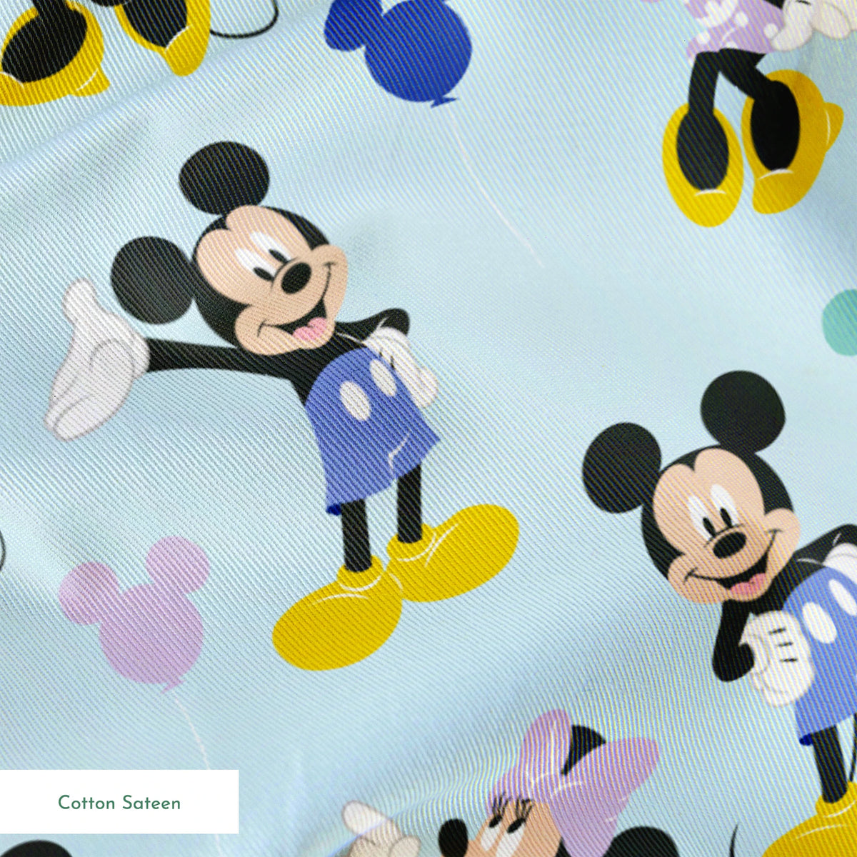 Pattern of Mickey and Minnie Mouse characters in various poses on light blue background springs sateen texture