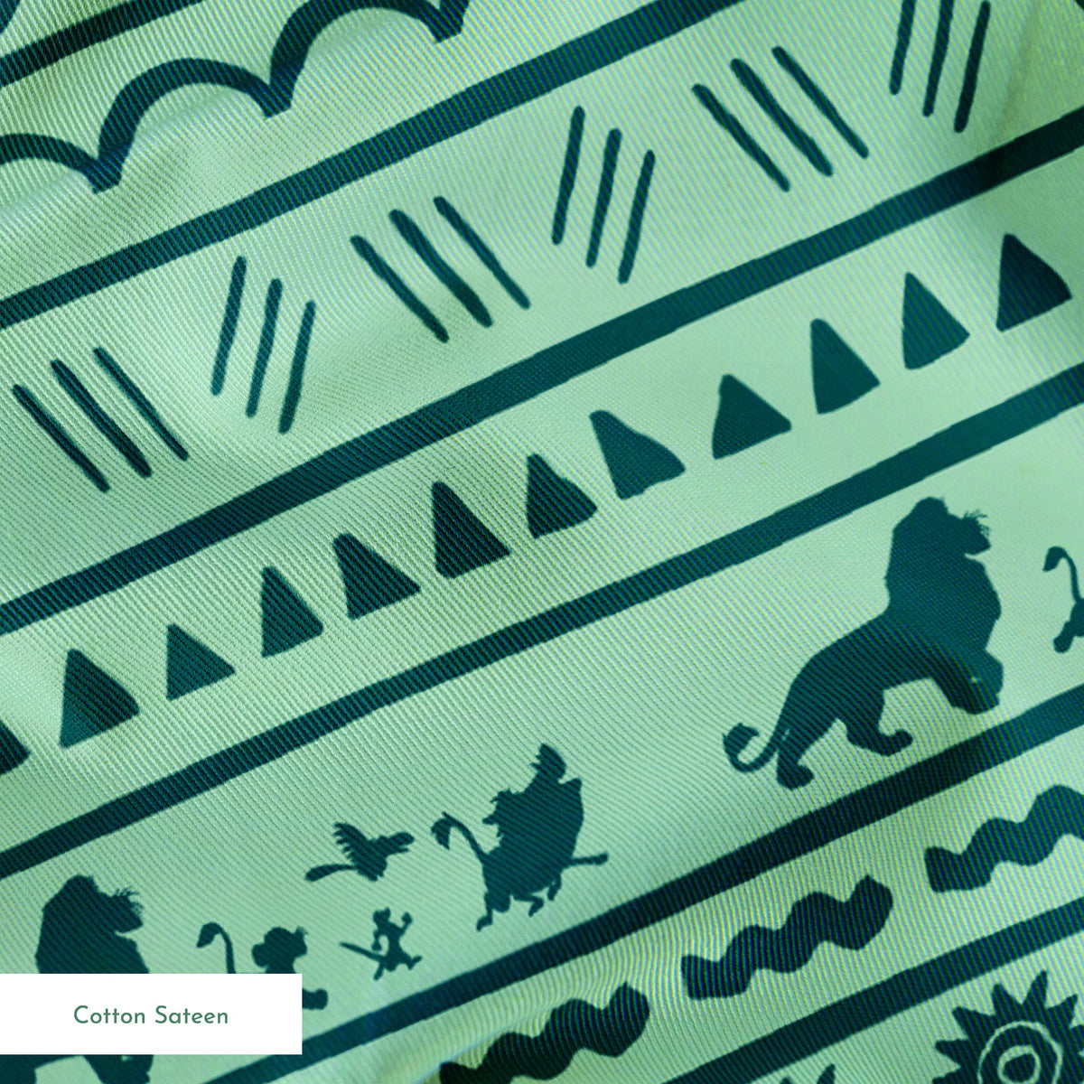 Traditional African-inspired pattern in dark teal on mint green with lions, spirals, triangles, and geometric motifs springs sateen texture