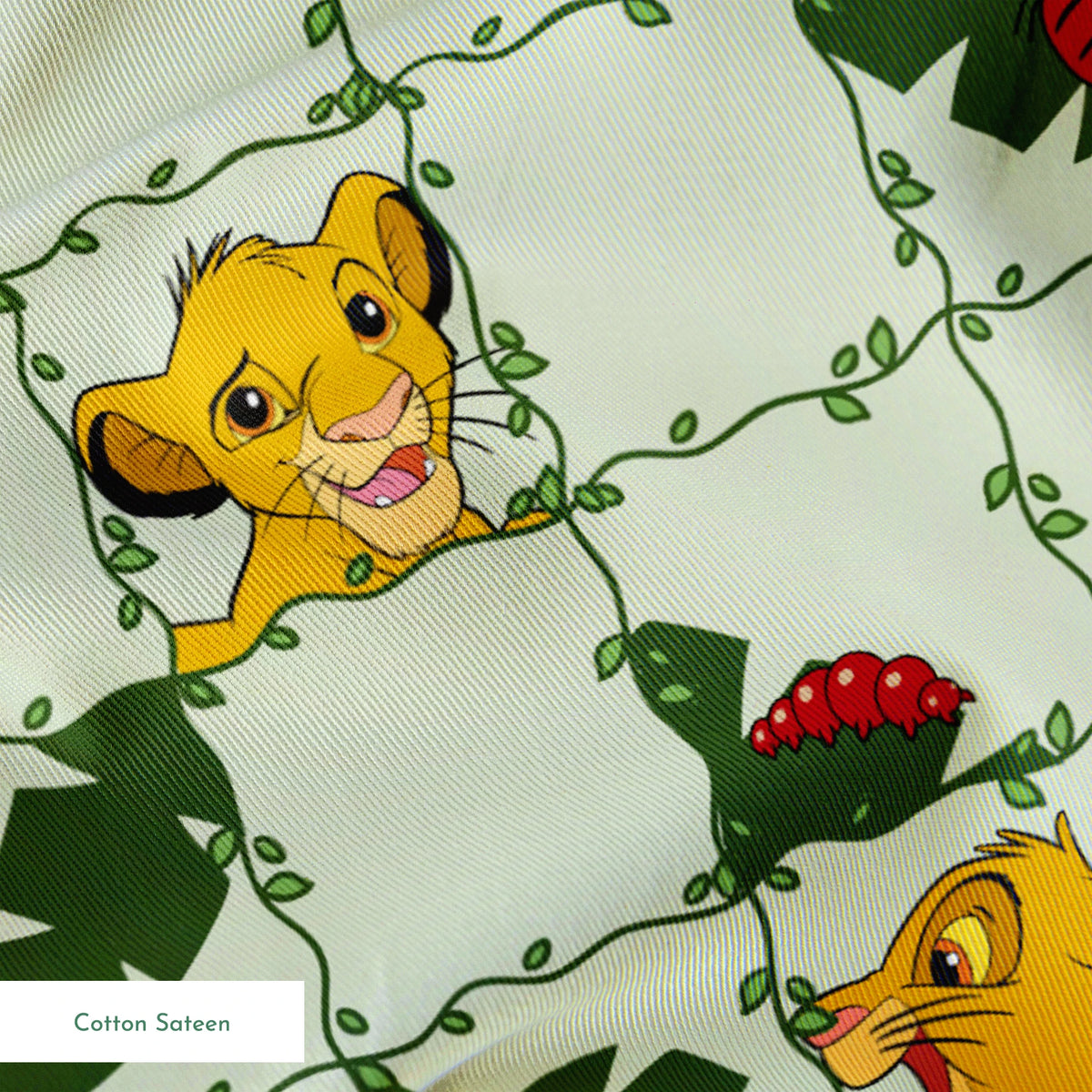 Young cartoon lion cubs with tropical leaves and "WILD" text on light green background pattern springs sateen texture