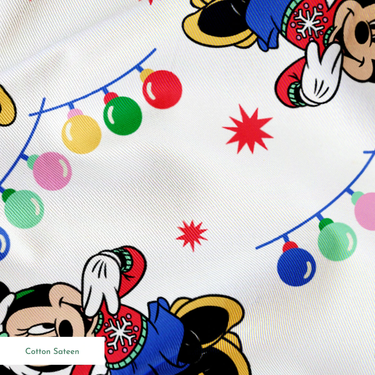 Minnie Mouse in Santa hats with blue outfits surrounded by colorful string lights and red stars on white background springs sateen texture
