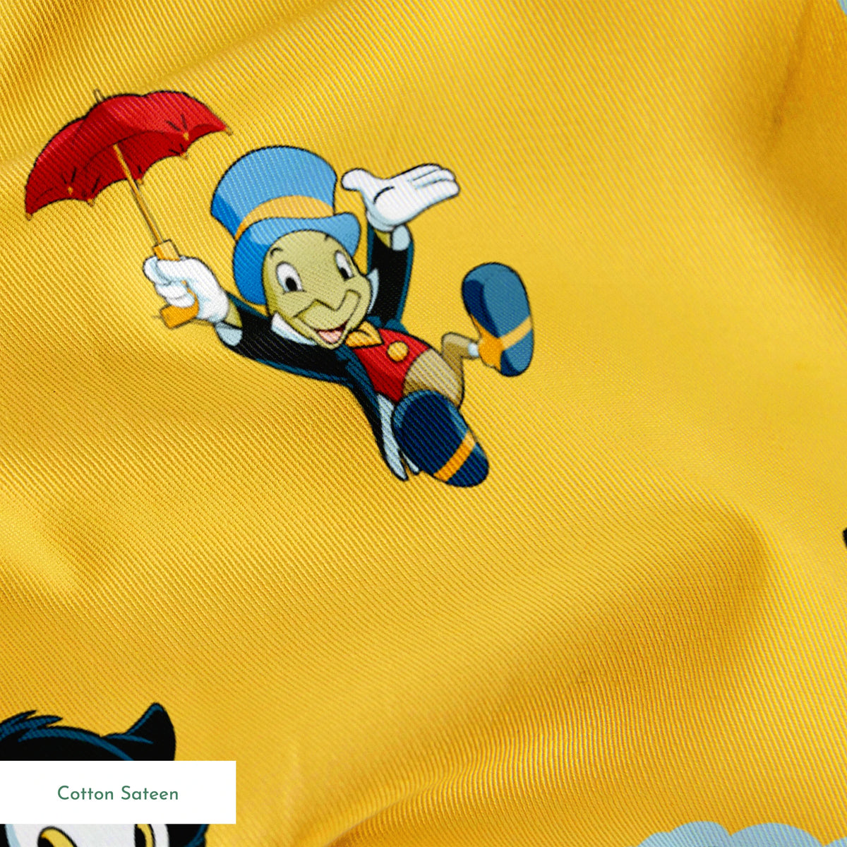 Pinocchio and Disney character pattern on yellow background with circular logos and red apples springs sateen texture