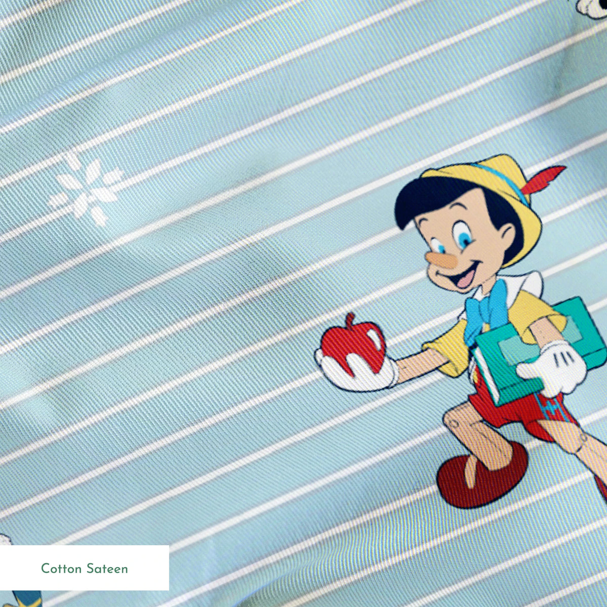 Cartoon pattern with boy character holding apple, black kittens, snowflakes on light blue striped background springs sateen texture