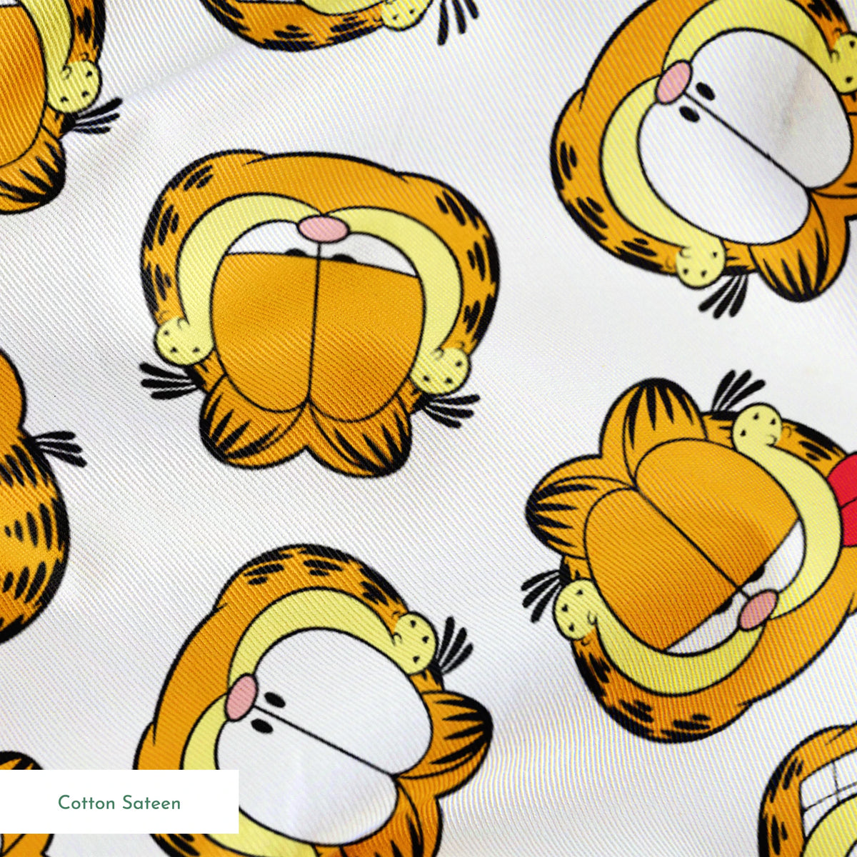 Pattern of cartoon cat faces with orange and yellow coloring against white background springs sateen texture