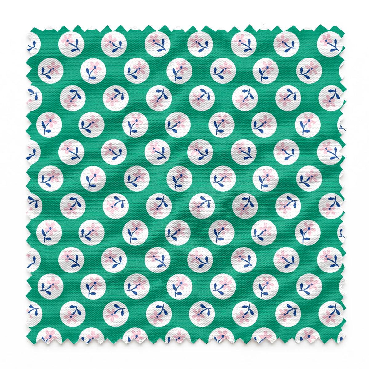 Pink flower motifs with blue stems on white circles against a green background springs swatch pinked
