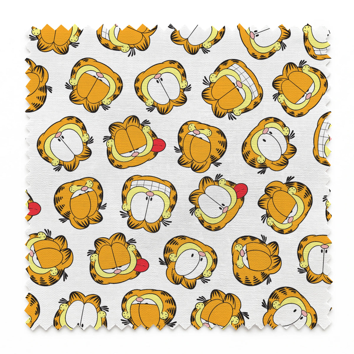 Pattern of cartoon cat faces with orange and yellow coloring against white background springs swatch pinked